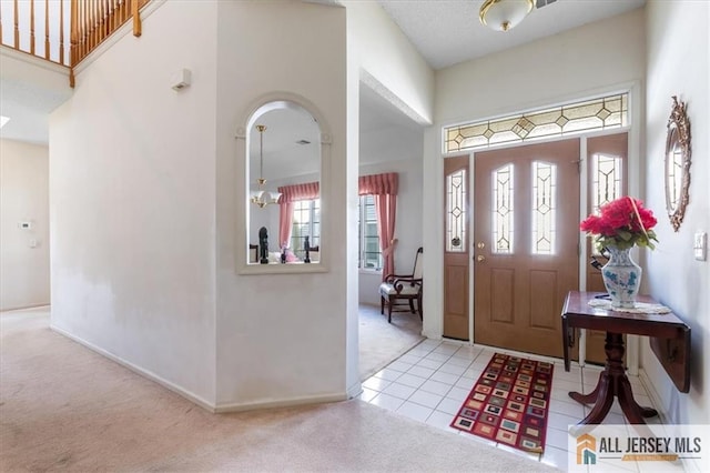carpeted foyer entrance featuring a wealth of natural light and baseboards
