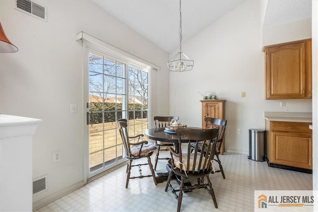 dining room with lofted ceiling, light floors, baseboards, an inviting chandelier, and visible vents