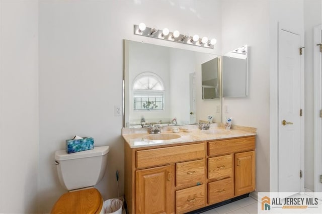 full bathroom with double vanity, toilet, tile patterned flooring, and a sink