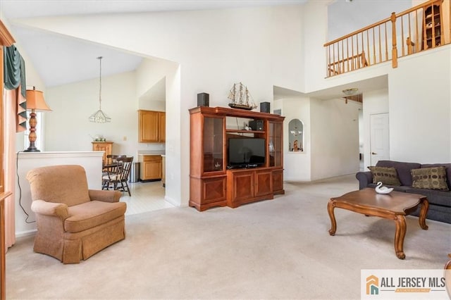 living area with light carpet and high vaulted ceiling