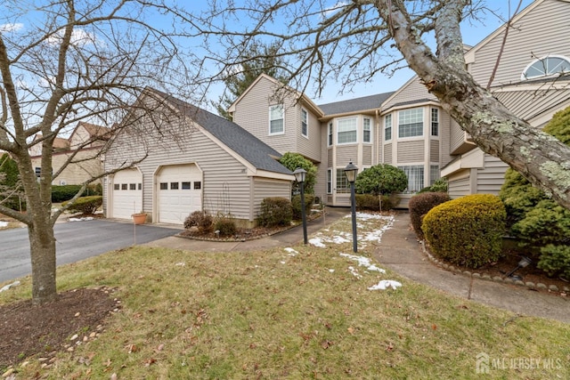 view of front of property with a shingled roof, entry steps, driveway, and an attached garage