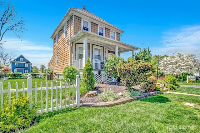 view of front of house with a porch, a front lawn, and fence
