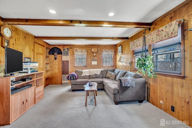 living room featuring wood walls, beam ceiling, and carpet flooring