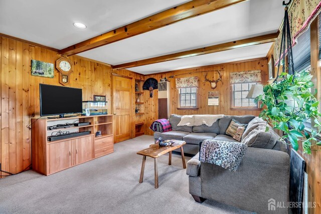 living room featuring wooden walls, carpet flooring, and beam ceiling