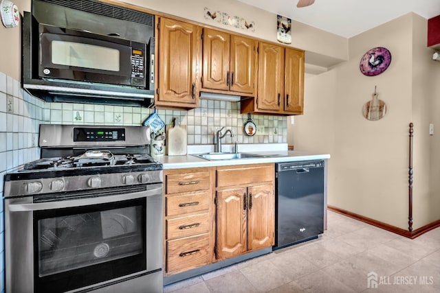 kitchen with baseboards, light countertops, a sink, backsplash, and black appliances