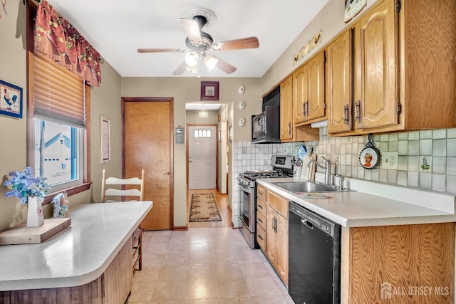 kitchen featuring ceiling fan, backsplash, light countertops, a sink, and black appliances