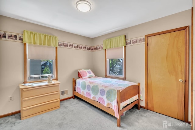 bedroom featuring baseboards, visible vents, and light carpet