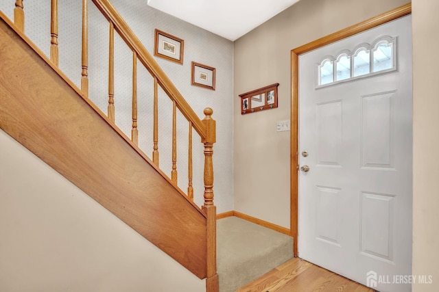 entrance foyer featuring baseboards, wood finished floors, and stairway