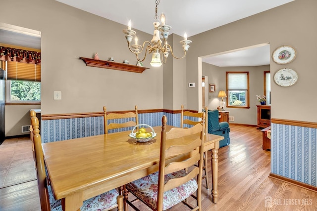 dining area featuring light wood-style floors, visible vents, a chandelier, and a wealth of natural light