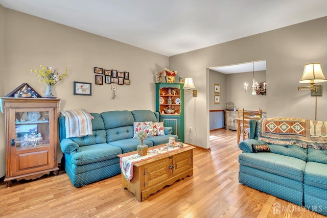 living area with an inviting chandelier and light wood-style flooring