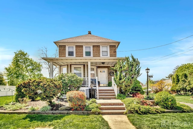 traditional style home featuring a porch, fence, a chimney, and roof with shingles