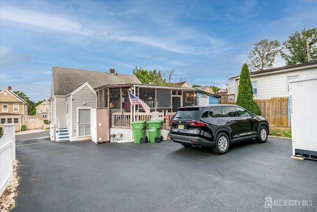12 Church St, Sayreville, NJ 08872 - view of front of house featuring a sunroom, a residential view, and a shingled roof