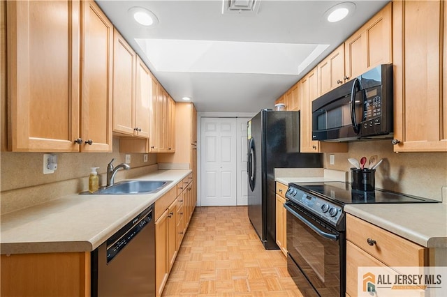 kitchen with visible vents, light brown cabinets, light countertops, black appliances, and a sink