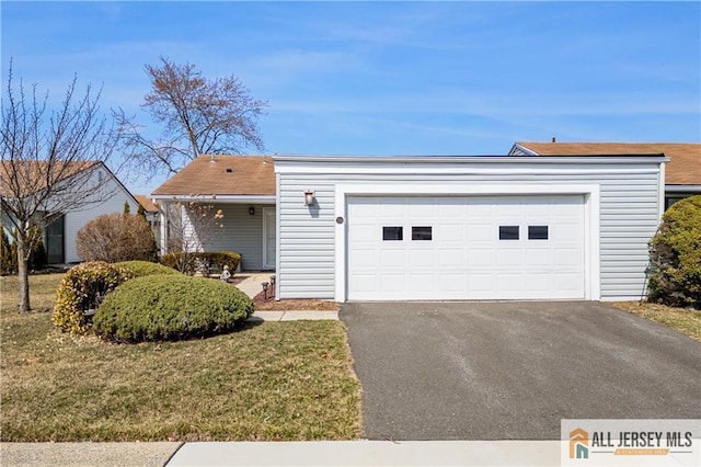 single story home featuring a front yard, an attached garage, and driveway