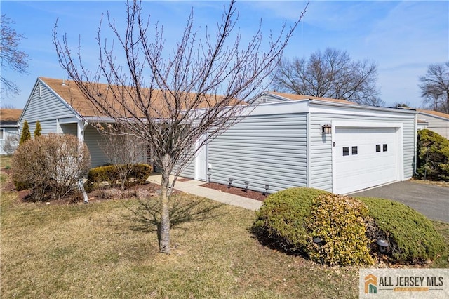 view of front of home featuring a front yard, a garage, and driveway