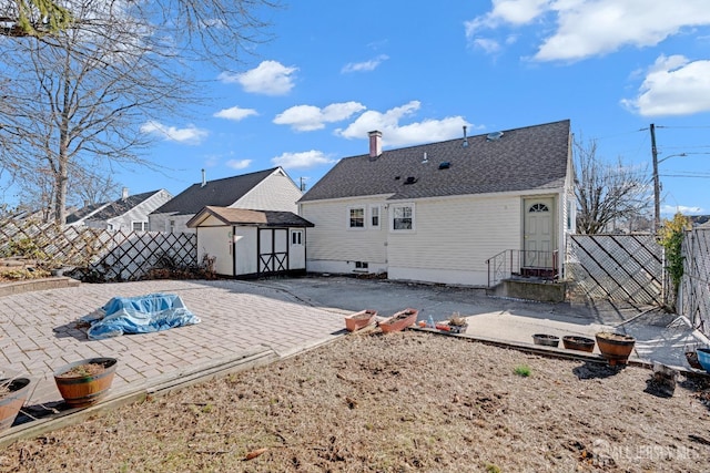 rear view of house with a shed and a patio