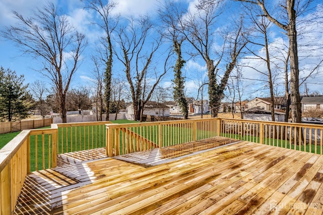 wooden terrace featuring a residential view, a fenced backyard, and a yard