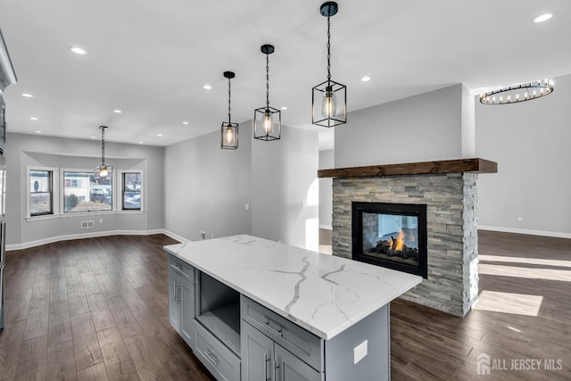 kitchen featuring open floor plan, dark wood-type flooring, gray cabinets, and pendant lighting