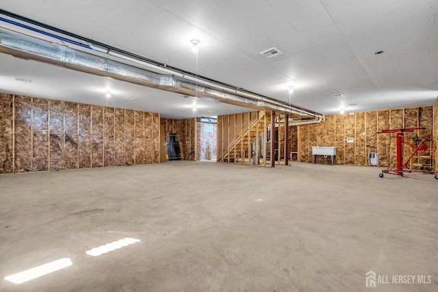 finished basement with visible vents, a sink, and stairway