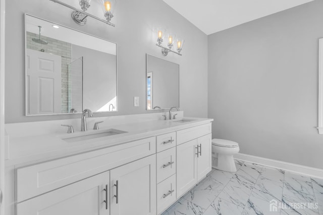 full bathroom with marble finish floor, a stall shower, a sink, and baseboards