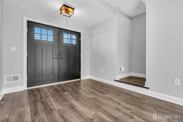 entryway featuring wood finished floors, visible vents, and baseboards