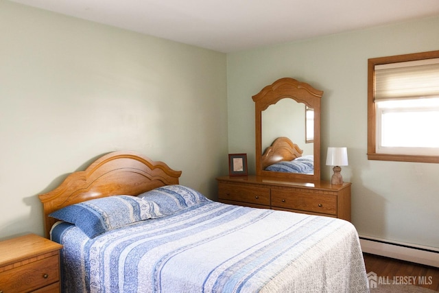 bedroom with a baseboard radiator and wood finished floors