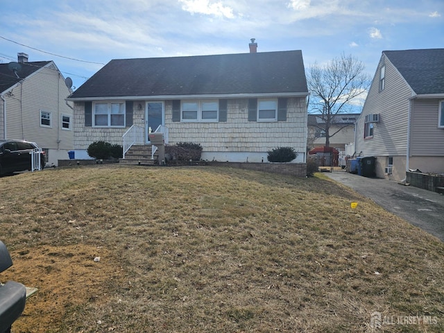 single story home featuring a chimney and a front lawn