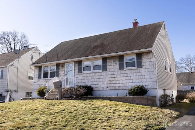 view of front facade with roof with shingles, a front lawn, and a chimney