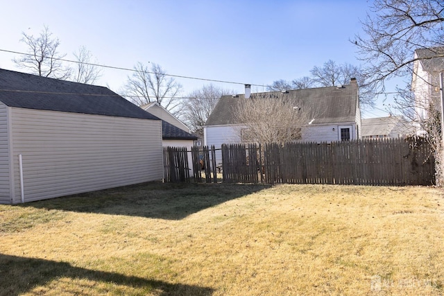 view of yard featuring an outdoor structure, fence, and a storage unit