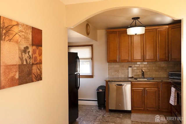 kitchen with range, freestanding refrigerator, arched walkways, dishwasher, and a sink