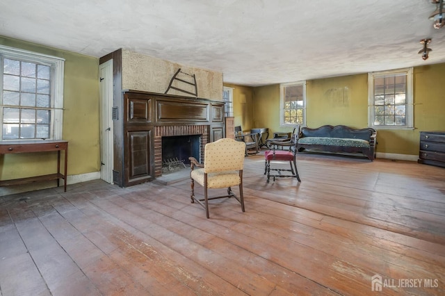 living room with a textured ceiling, a fireplace, and hardwood / wood-style flooring