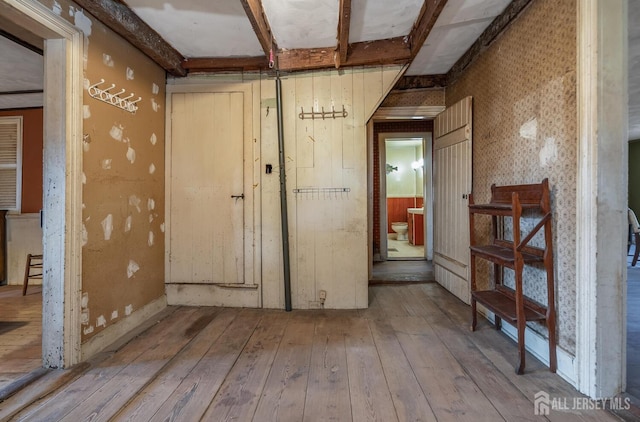 miscellaneous room featuring light wood-type flooring and beamed ceiling