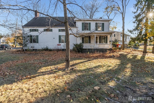 back of property featuring a porch and a yard