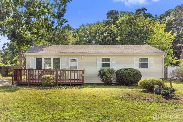 view of front of house featuring a front lawn and a deck