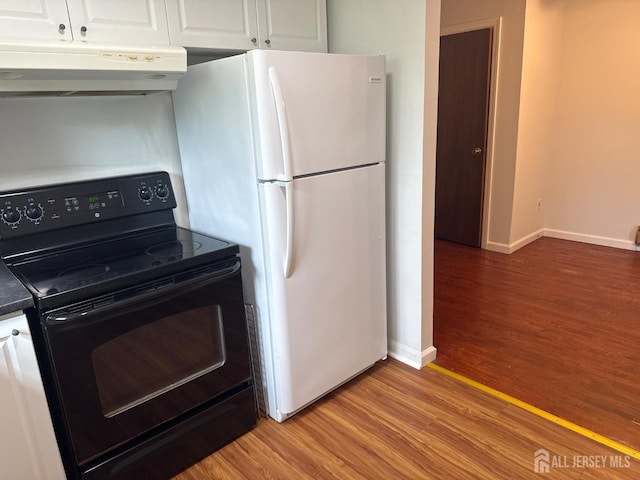 3013 Cromwell Ct, Hillsborough, NJ 08844 - kitchen featuring black range with electric stovetop, under cabinet range hood, freestanding refrigerator, light wood-style floors, and white cabinetry