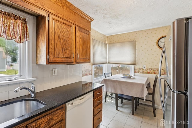 30 Clark Pl, Avenel, NJ 07001 - kitchen with freestanding refrigerator, dishwasher, wallpapered walls, brown cabinets, and a textured ceiling
