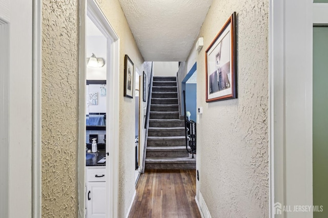 30 Clark Pl, Avenel, NJ 07001 - hallway featuring a textured wall, dark wood-type flooring, a textured ceiling, and stairs