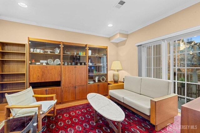 living room with ornamental molding and hardwood / wood-style floors