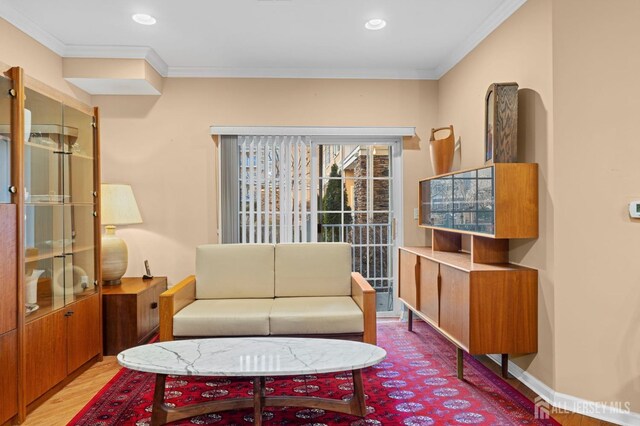 living room featuring hardwood / wood-style flooring and crown molding