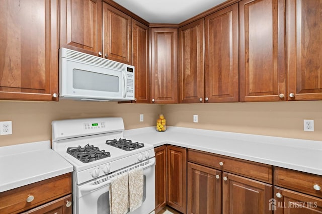 540 Cranbury Rd Unit 107, East Brunswick, NJ 08816 - kitchen with white appliances, brown cabinetry, and light countertops