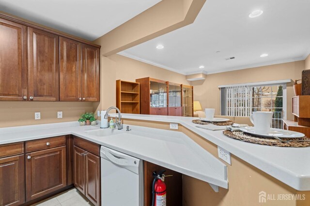 kitchen with dishwasher, sink, ornamental molding, kitchen peninsula, and light tile patterned flooring