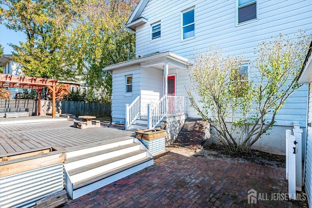 property entrance featuring a pergola and a deck