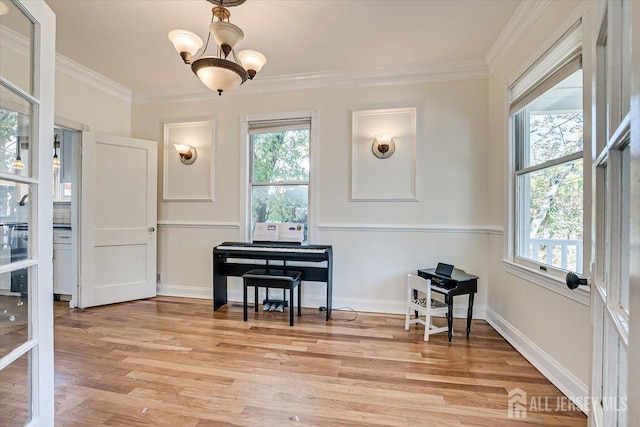 misc room featuring a notable chandelier, light wood-type flooring, ornamental molding, and a wealth of natural light