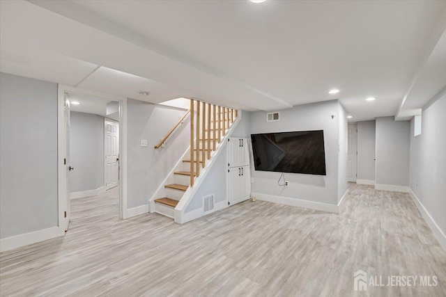 basement featuring a healthy amount of sunlight and light wood-type flooring