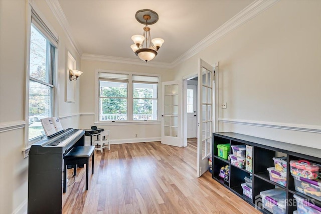 miscellaneous room with french doors, an inviting chandelier, light hardwood / wood-style flooring, and ornamental molding