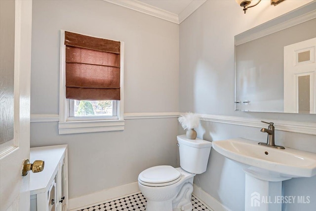 bathroom featuring tile patterned flooring, toilet, ornamental molding, and sink