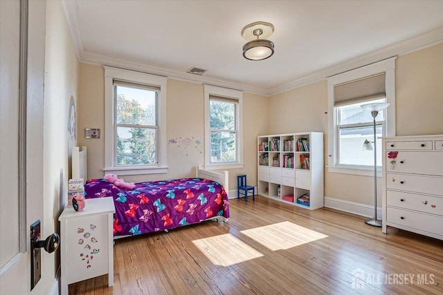 bedroom featuring light hardwood / wood-style floors and crown molding