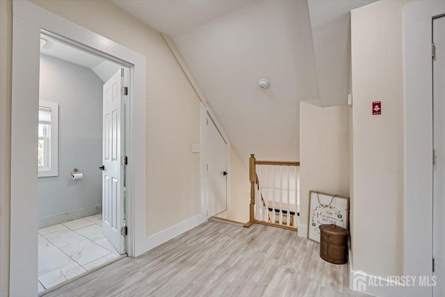 staircase with wood-type flooring and lofted ceiling