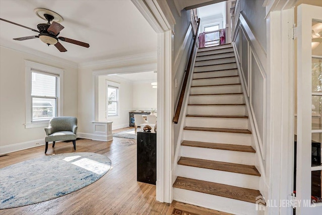 stairway with hardwood / wood-style flooring, ceiling fan, and crown molding