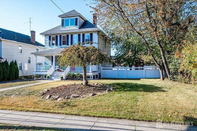 view of front of home featuring covered porch and a front yard